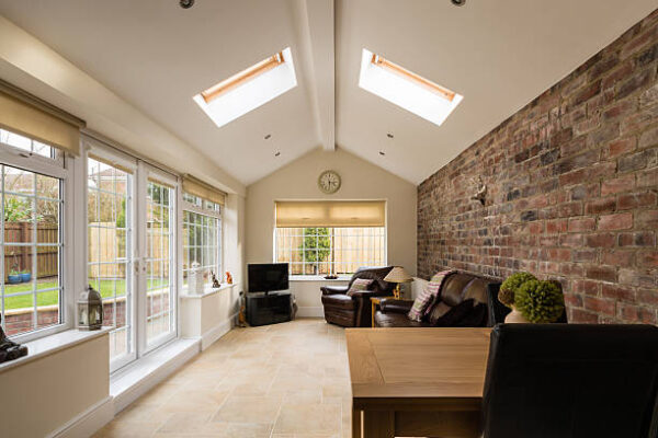 Modern Sunroom or conservatory extending into the garden with a featured brick wall