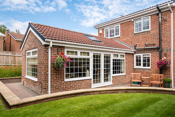 Modern Sunroom or conservatory extending into the garden, surrounded by a block paved patio